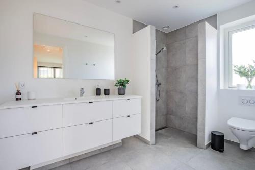 a white bathroom with a sink and a toilet at Spacious family house in Copenhagen