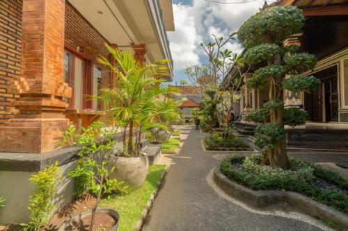 a street with trees and plants in front of a building at Pondok Lulik Homestay Canggu in Canggu