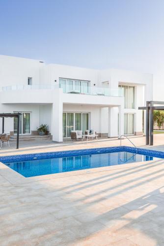 a swimming pool in front of a house at Pickalbatros Golf Luxury Suites - All Inclusive in Sharm El Sheikh