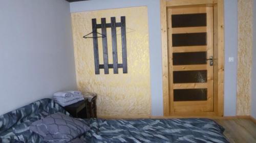 ein Schlafzimmer mit einer Tür und einem Bett sowie einer Tür mit einem Fenster in der Unterkunft Pid lisochkom in Werchowyna