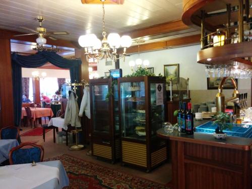 a bar in a restaurant with a counter and a table at Hotel Seemöwe in Simmerath