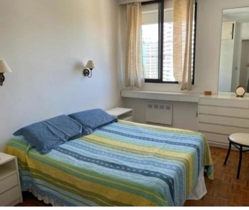 プンタ・デル・エステにあるApartapuntaのベッドルーム1室(カラフルな毛布、窓付)