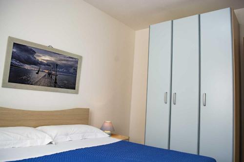 een slaapkamer met een bed en een grote kast bij Appartamenti in Via Schipa Pescoluse in Marina di Pescoluse