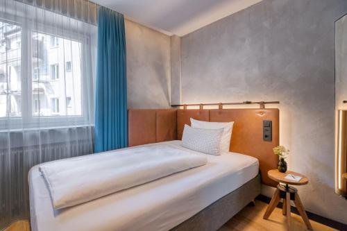 a bedroom with a large bed and a window at Unsöld's Factory Hotel in Munich