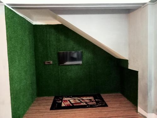 een kamer met een groene muur met een tv erop bij Ellys home stay in Guwahati