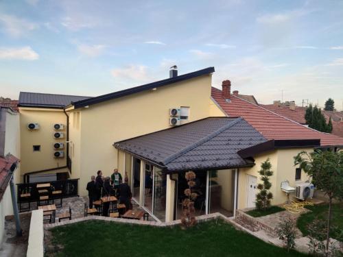 2 personnes assises sur la terrasse couverte d'une maison dans l'établissement Fruškogorski biser, à Sremski Karlovci