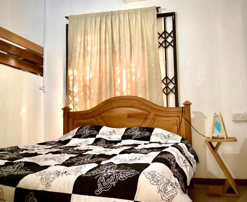 a bedroom with a black and white bed with a window at Original Villa in Trou dʼ Eau Douce