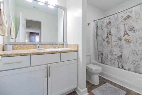 a bathroom with a sink and a toilet and a mirror at Vinings Vista Your Serene Escape in Georgia in Atlanta