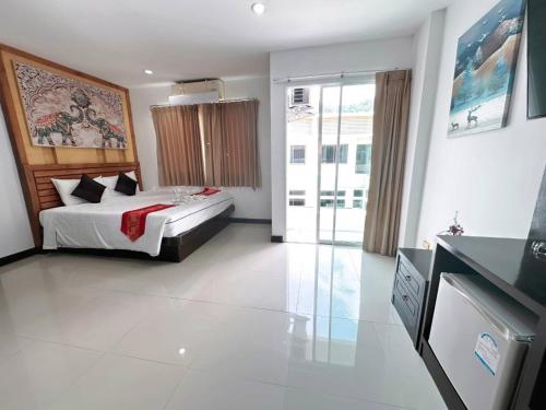 a bedroom with a bed and a large window at Abby's House Hotel in Patong Beach