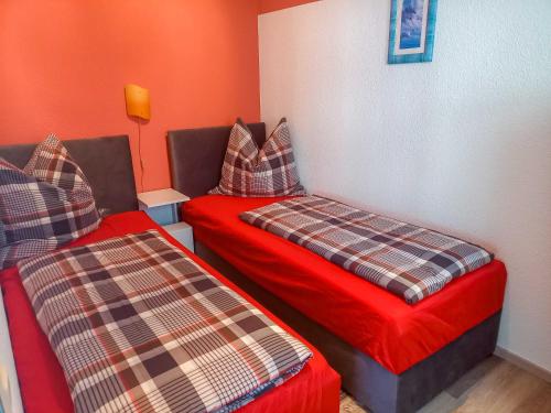 two beds in a room with orange walls at Ferienbungalow Stahlbrode in Stahlbrode