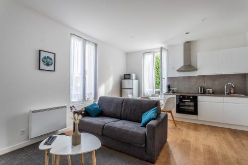 un salon avec un canapé et une cuisine dans l'établissement Le Musée 1, Cosy 2 pièces, à Bergerac