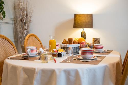 a table with a white table cloth with food on it at Le Sarcinoé in Sergines