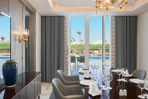 a dining room with a table and chairs and a pool at Pickalbatros Golf Luxury Suites - All Inclusive in Sharm El Sheikh
