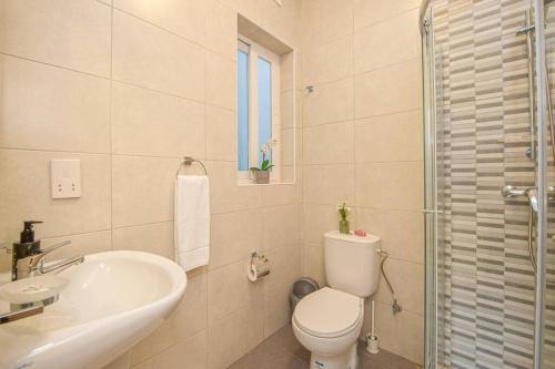 un bagno bianco con un water e un lavandino di Sea View Suite! a Marsalforn