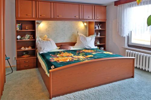 a bedroom with a large bed with a wooden headboard at Ferienwohnung an der Drei-Kaiser-Eiche in Freest