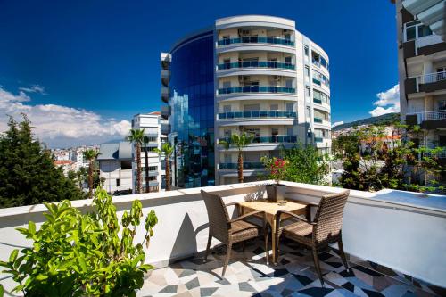 a table and chairs on a balcony with a building at 8 Rooms House in Balcova