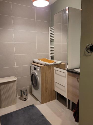 une cuisine avec lave-linge dans la salle de bains dans l'établissement F3 neuf tout équipé de 62m2 centre ville, à Annecy