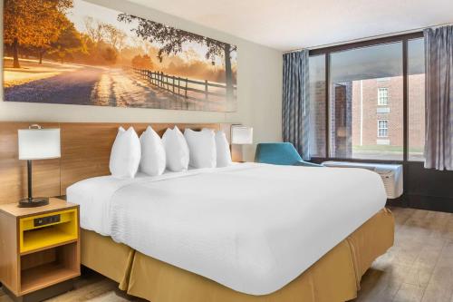 a hotel room with a large bed and a window at Days Inn & Suites by Wyndham Rocky Mount Golden East in Rocky Mount