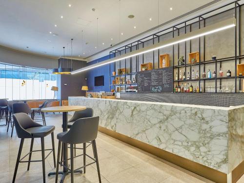 a bar in a restaurant with tables and chairs at Mercure Perth in Perth