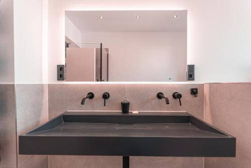 La salle de bains est pourvue d'un lavabo et d'un miroir. dans l'établissement unique Cityresidenz nähe Münster - WE01, à Ulm