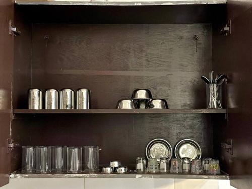 a shelf filled with lots of silver items on it at 2 Bhk apt near Manipal hospital by RDBL Hospitality Private limited in New Delhi