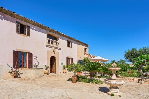 a large house with a fountain in a courtyard at Finca Tanca in Calonge