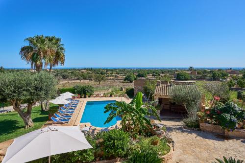 a view of a pool with umbrellas and trees at Finca Tanca in Calonge