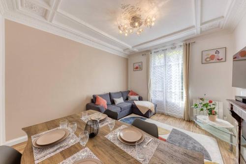 un salon avec une table et un canapé dans l'établissement Proche PARIS, gare RER C à 2 min à pieds, Notre Dame à 15min, Parking privé et TRAVELLER AWARDS 2025, à Choisy-le-Roi
