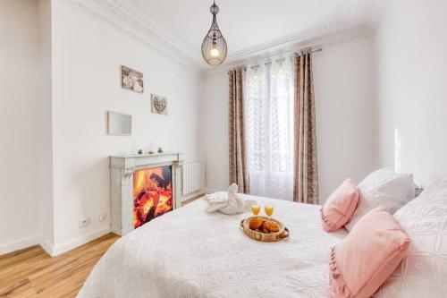 a white bedroom with a bed with a fireplace at Idéalement placé ,10 min de Paris, 2 min à pied du RER C et Parking Privé in Choisy-le-Roi