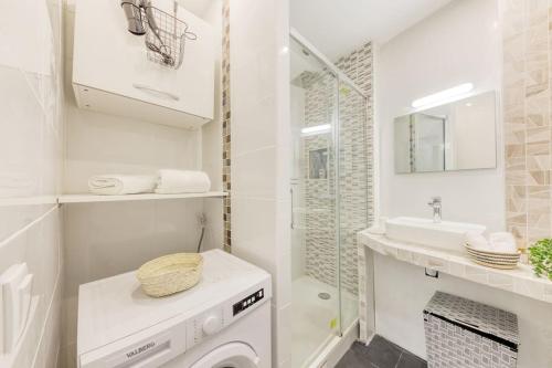 baño blanco con lavadora y lavamanos en Le Charmant à 10 min de Paris, à 2 min à pied du RER C - L'Idéal pour les JO avec Parking Privé!, en Choisy-le-Roi