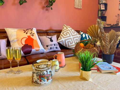 a couch with a table with glasses of wine at Elsewhere Villa by Hill Staytion in Mahabaleshwar