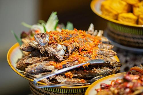 a pile of food on a plate on a table at THE 1O1 Jakarta Sedayu Darmawangsa in Jakarta