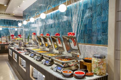a buffet line with many plates of food at THE 1O1 Jakarta Sedayu Darmawangsa in Jakarta