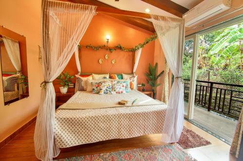 a bedroom with a canopy bed and a balcony at Elsewhere Villa by Hill Staytion in Mahabaleshwar
