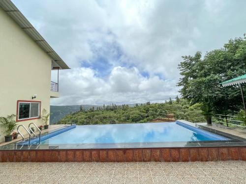 a swimming pool in the backyard of a house at Elsewhere Villa by Hill Staytion in Mahabaleshwar