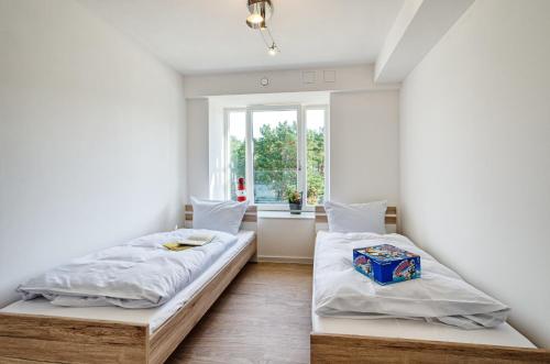 - une chambre avec 2 lits et une fenêtre dans l'établissement FeWo Prora - Arkonas Strandperle, à Binz