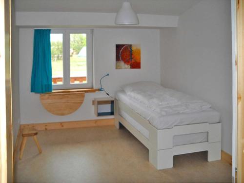 a small bedroom with a bed and a window at Biohof Medewege in Schwerin