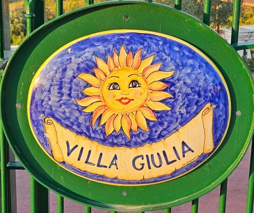 a sign on a fence with a sun painted on it at Villa Giulia - Cilento - Giungano in Giungano