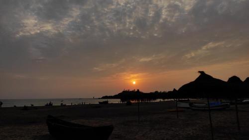 a sunset on the beach with the sun setting at On the beach in Palolem