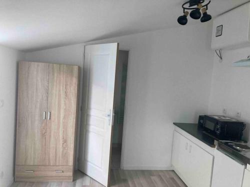 Zimmer mit einer Küche mit einer Tür und einer Theke in der Unterkunft Maisonnette neuve avec jardin privatif in Saran
