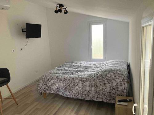 ein Schlafzimmer mit einem Bett und einem TV an der Wand in der Unterkunft Maisonnette neuve avec jardin privatif in Saran