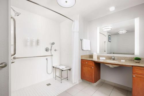 baño blanco con ducha y lavamanos en Homewood Suites by Hilton Corpus Christi en Corpus Christi