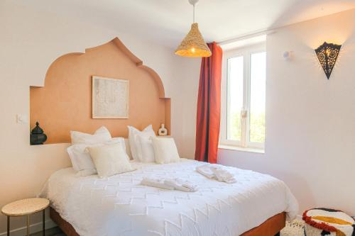 - une chambre avec un grand lit blanc et une fenêtre dans l'établissement L' Oriental Suite de Luxe, à Serrières