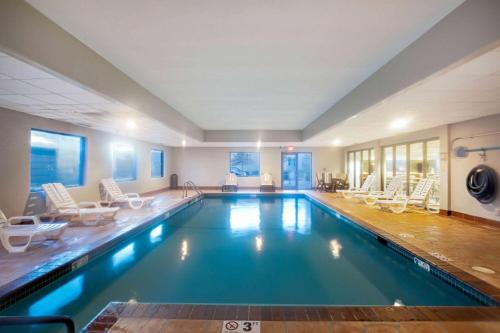 a large swimming pool with white chairs at La Quinta by Wyndham Omaha Airport Downtown in Omaha
