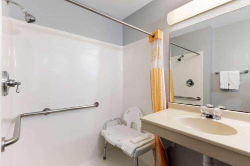 a white bathroom with a sink and a mirror at La Quinta by Wyndham Omaha Airport Downtown in Omaha
