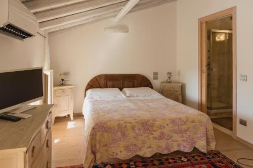 um quarto com uma cama e uma televisão de ecrã plano em La Casetta in Valpolicella em Monte