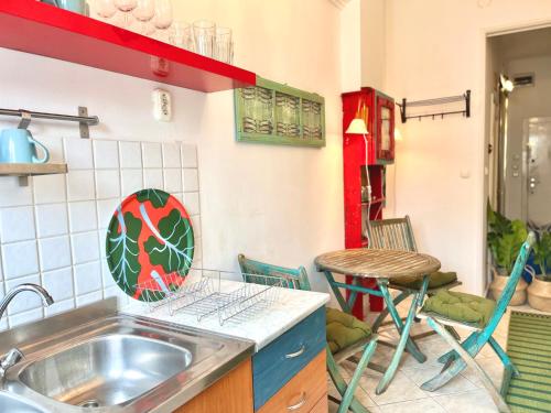 a kitchen with a sink and a table and chairs at Cosy Art flats in central Budapest in Budapest