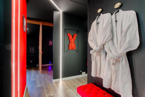 een kamer met witte badjassen aan de muur bij L'Interdit Suite de Luxe in Serrières