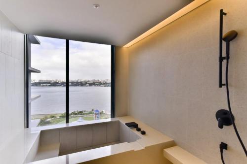 a bathroom with a large window overlooking the water at Four Points by Sheraton Taipei Bali in Bali