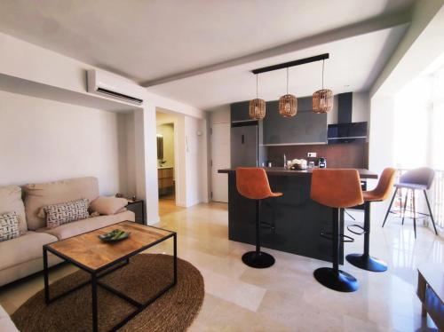 ein Wohnzimmer mit einem Sofa und einem Tisch in der Unterkunft Casa Carmela Fuengirola in Fuengirola